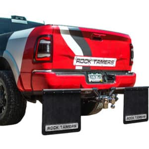 Rock Tamers mudflap system installed on a red truck, providing rear protection during towing.